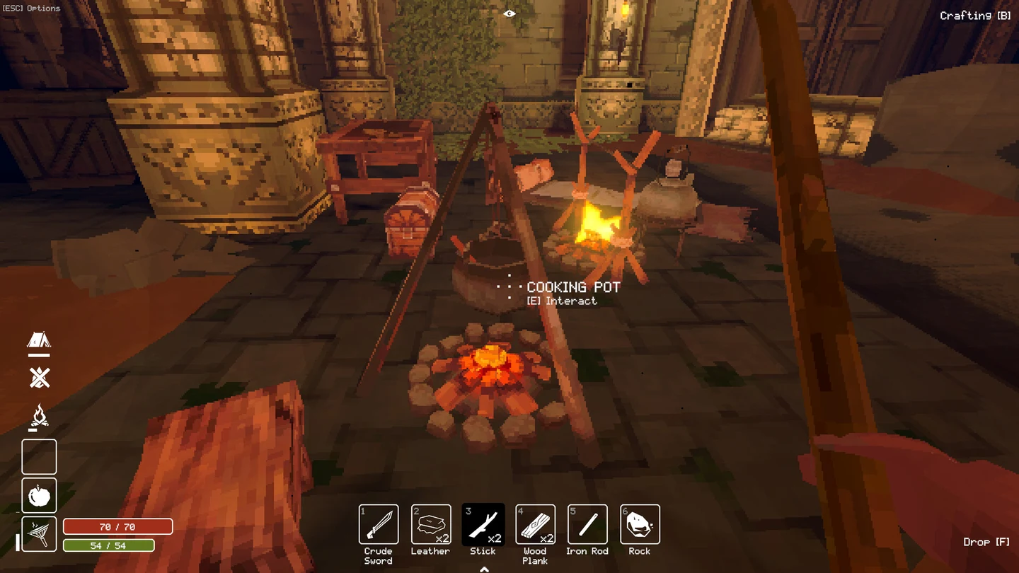 A Cooking Pot suspended above a campfire beside chests and a roasting fire